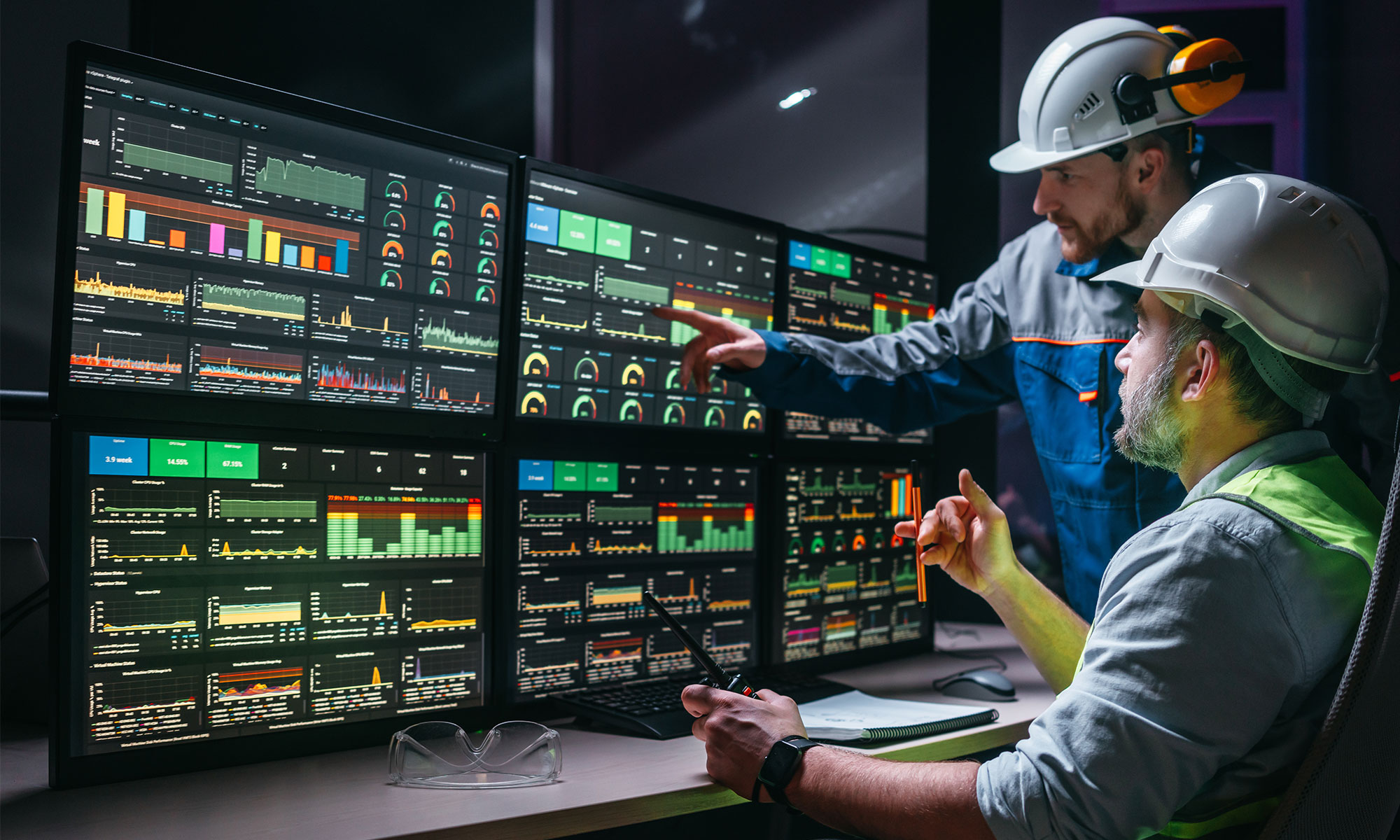 Two facility operators checking and analyzing process on screens