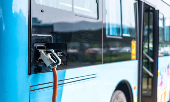 Un autobus électrique branché à une borne de recharge.