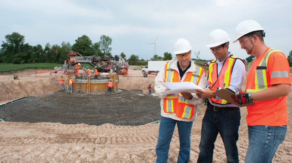 B&M project engineers at a turbine base construction site discussing progress