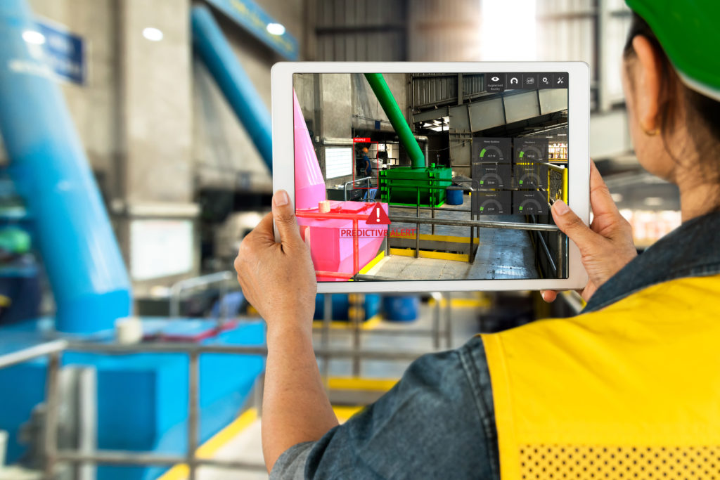 B&M Energy Project Manager holding a handheld tablet showing a dashboard of energy and equipment performance.