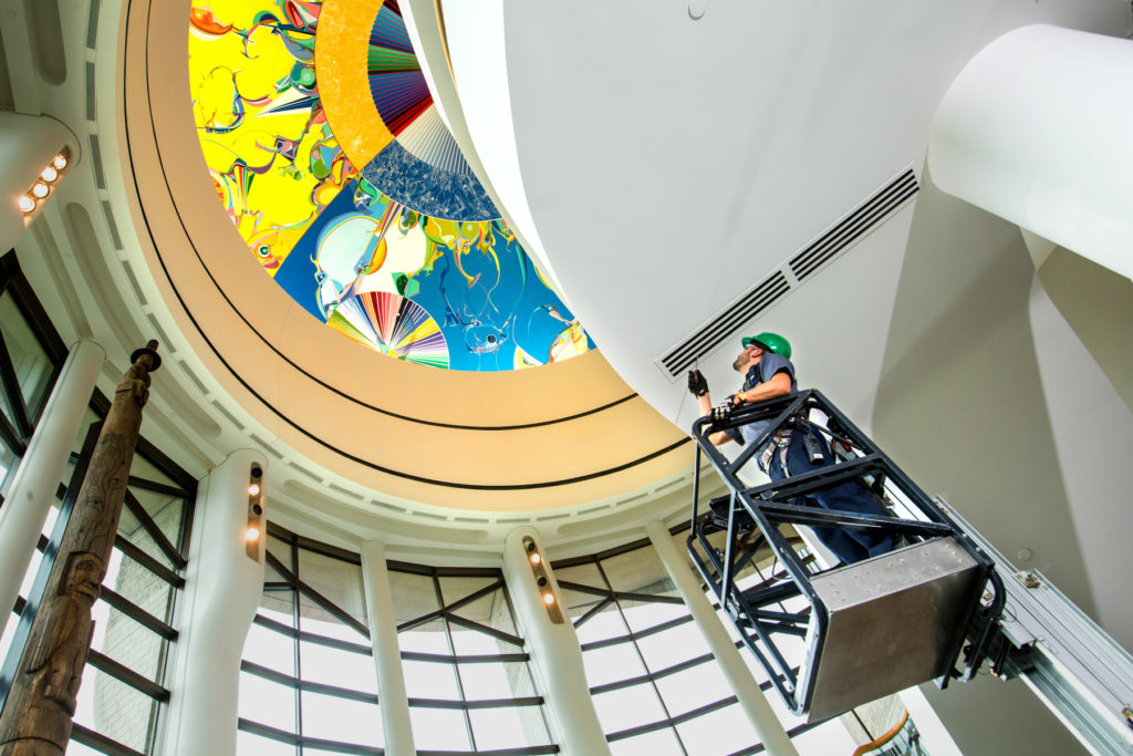 Black & McDonald Facility Management Professional inspecting the stage lighting at a museum.
