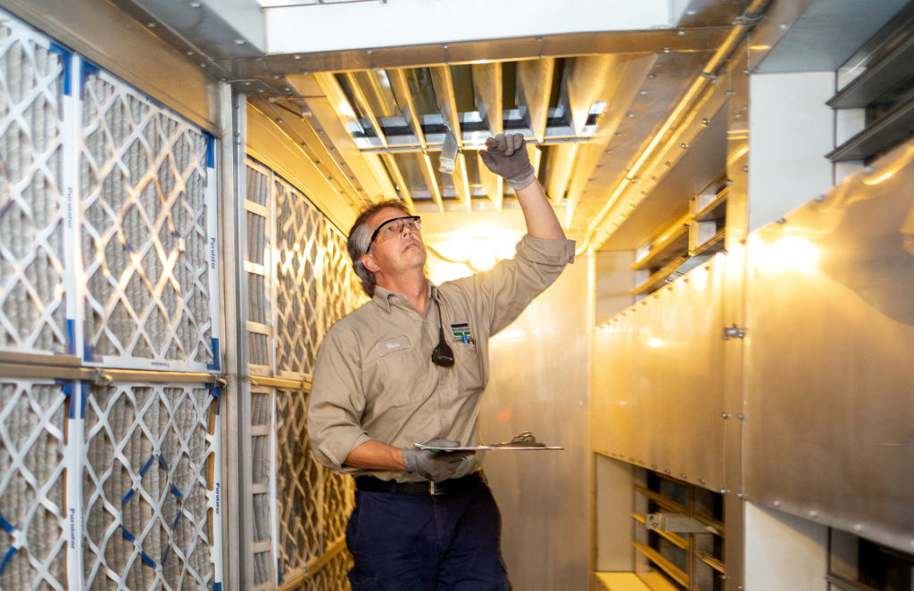 B&M HVAC technician inspecting and changing HVAC filters.