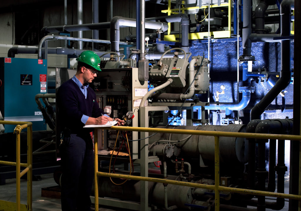 Un technicien des services de B&M entretient un système industriel de réfrigération et de refroidissement