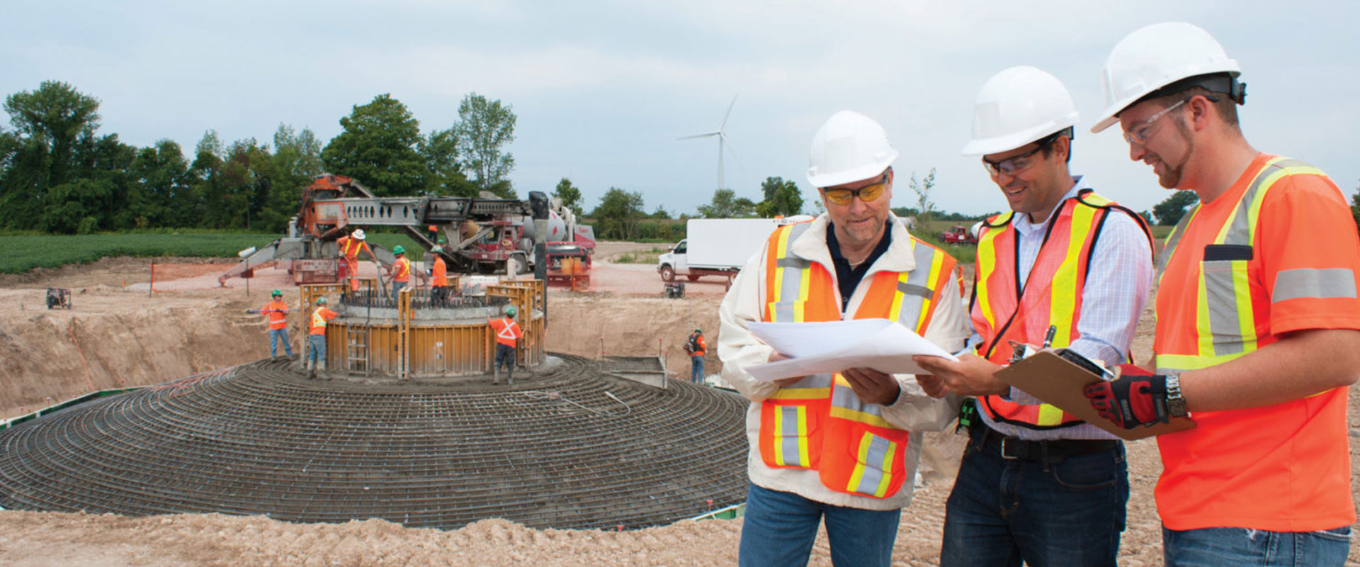 B&M project engineers and managers at a turbine base construction site discussing progress