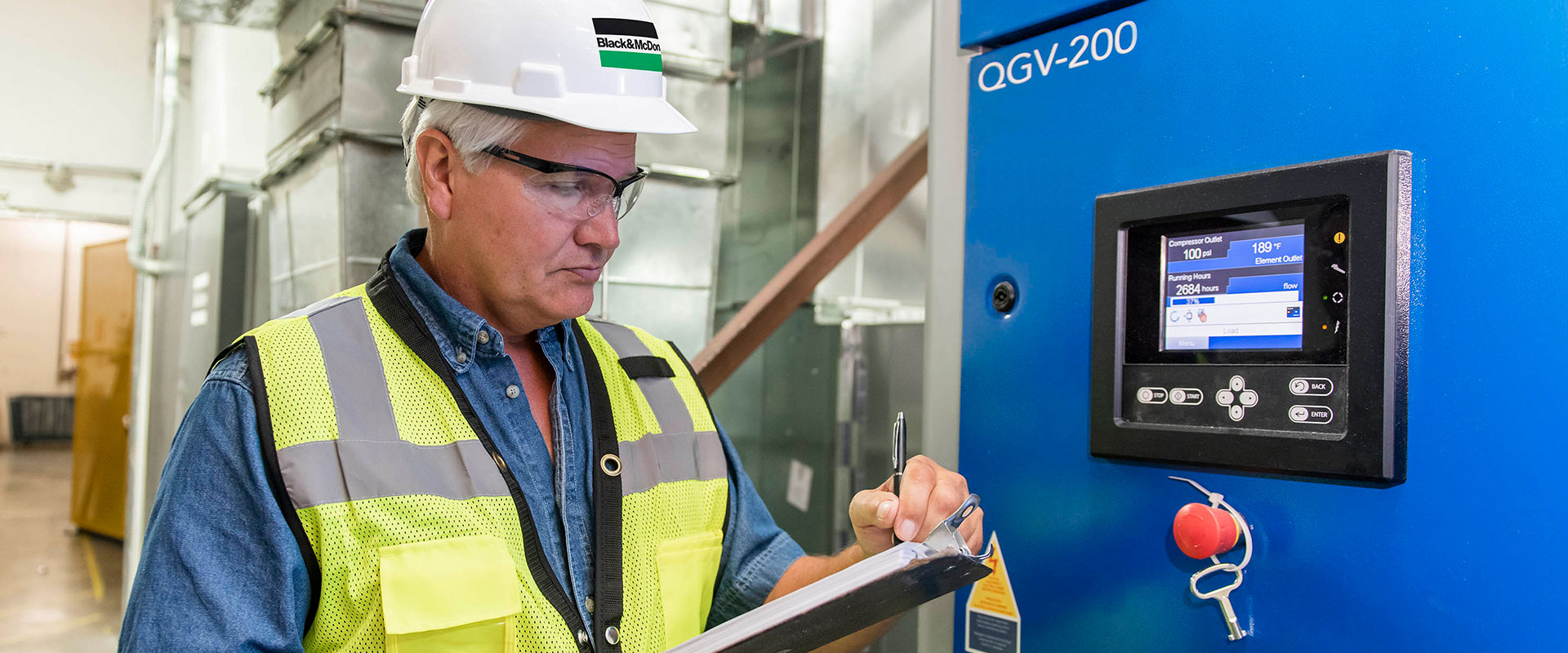 Electrical project manager inspecting smart metering installed by a B&M service technician at a plant