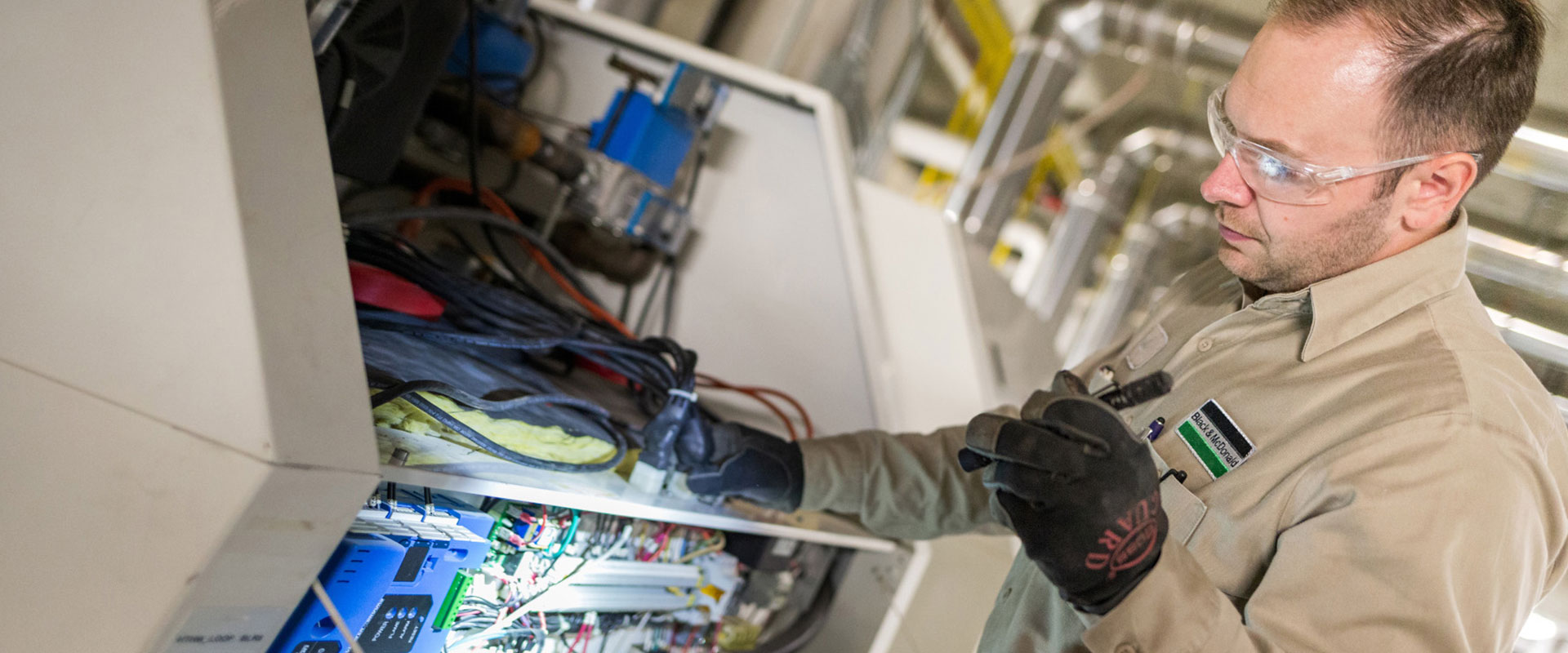Un technicien des services de Black & McDonald inspecte une pièce d’équipement électrique