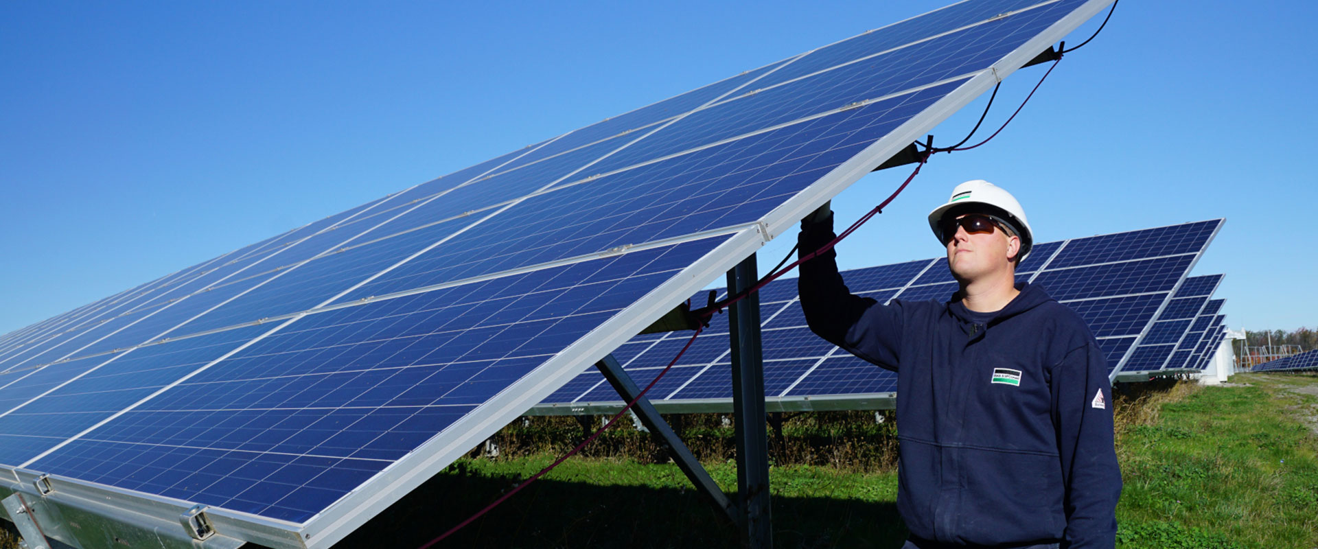 Un employé de B&M inspecte le câblage des panneaux solaires du réseau collecteur